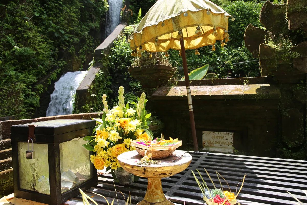 Traditional Balinese canang sari offering with incense and flowers