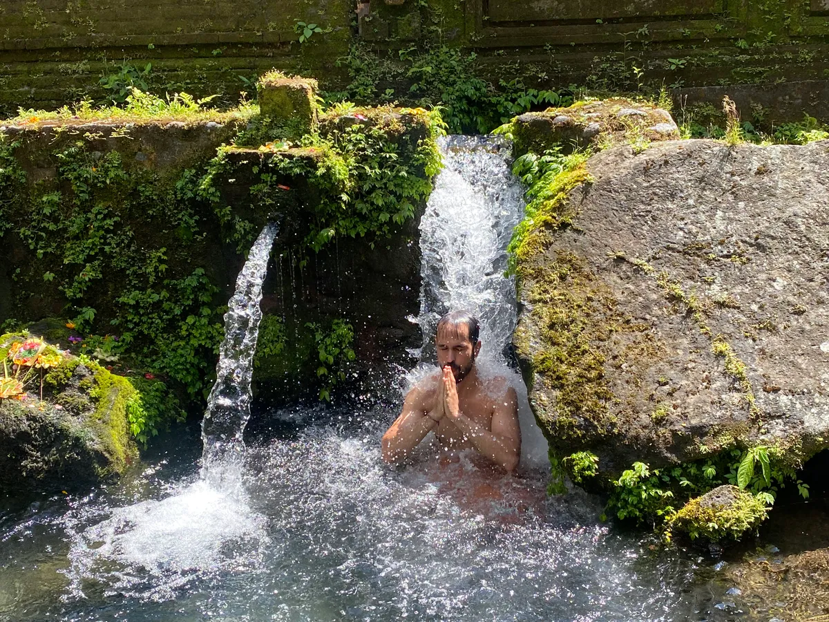 Close-up of sacred spring water flowing through carved stone
